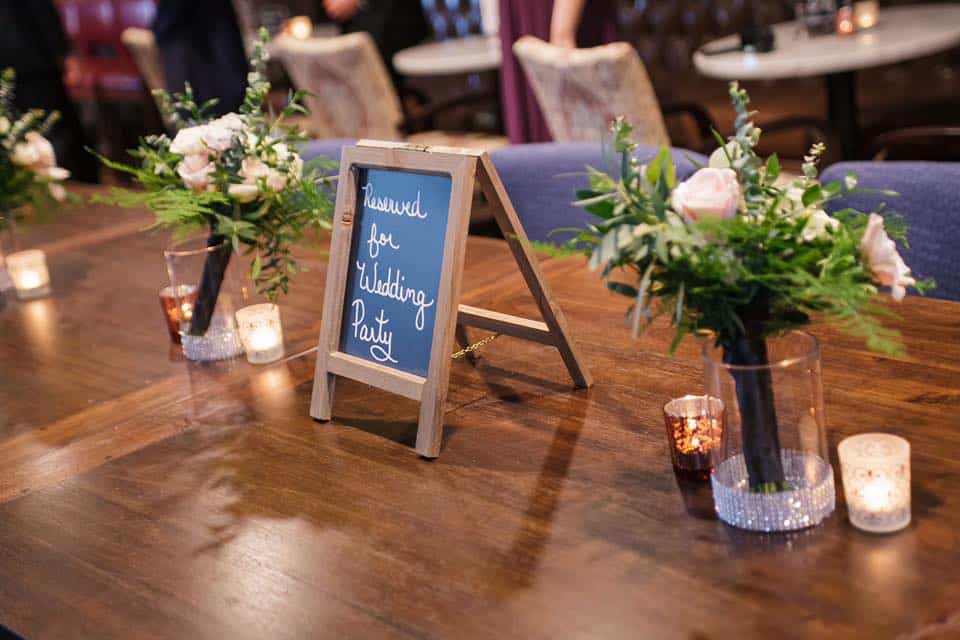 mini chalkboard that says reserved for wedding party on wood table